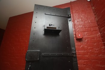 Original steel jail door with red wall
